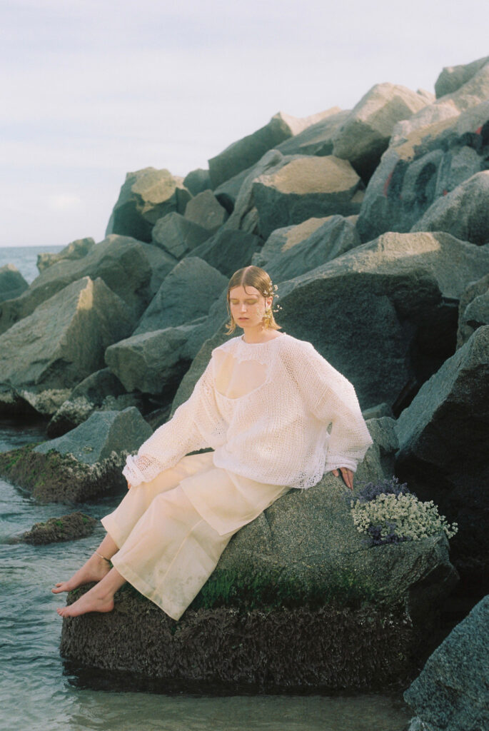 Mujer sobre roca en el mar, producción de moda